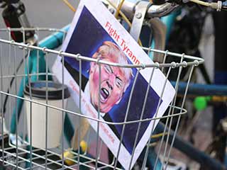 Bicycle basket containing picture of Donald Trump with 'Fight Tyranny' heading