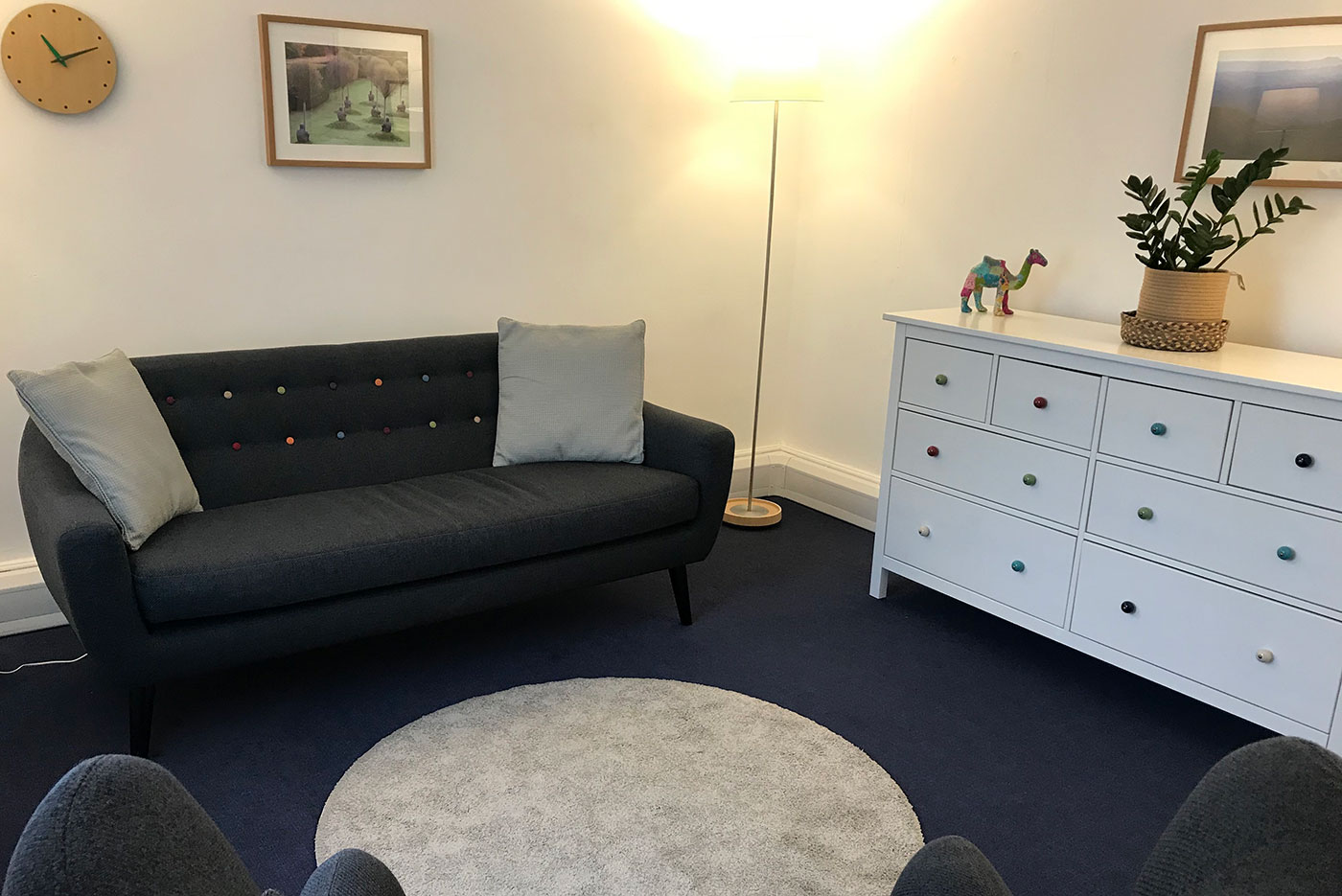 London Bridge Room 27: sofa, rug, chest of drawers, lamp, plant