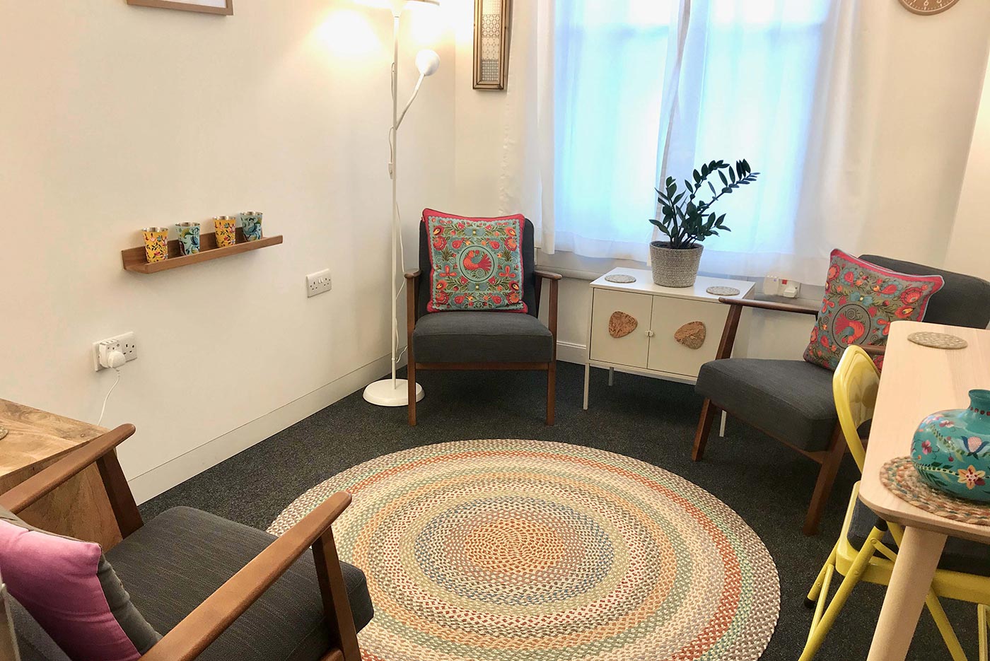 King's Cross Road Room 302: 2 arm chairs, rug, table and chair, lamp, cabinet and plant